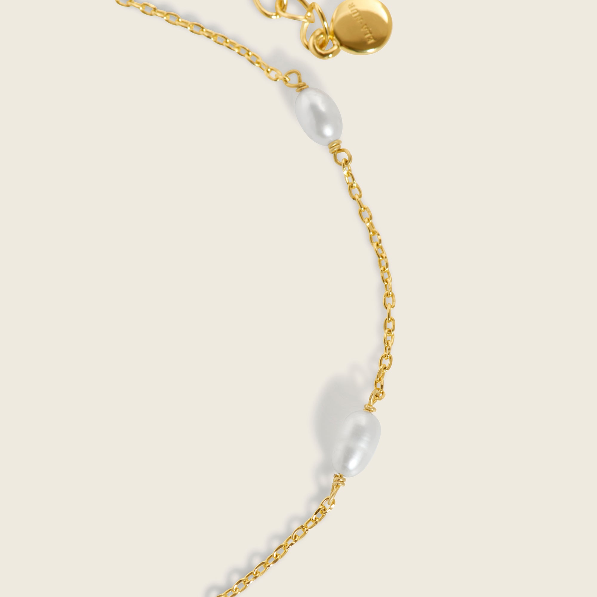 Radiant 18k gold paired with opulent freshwater pearls on an adjustable gold chain bracelet