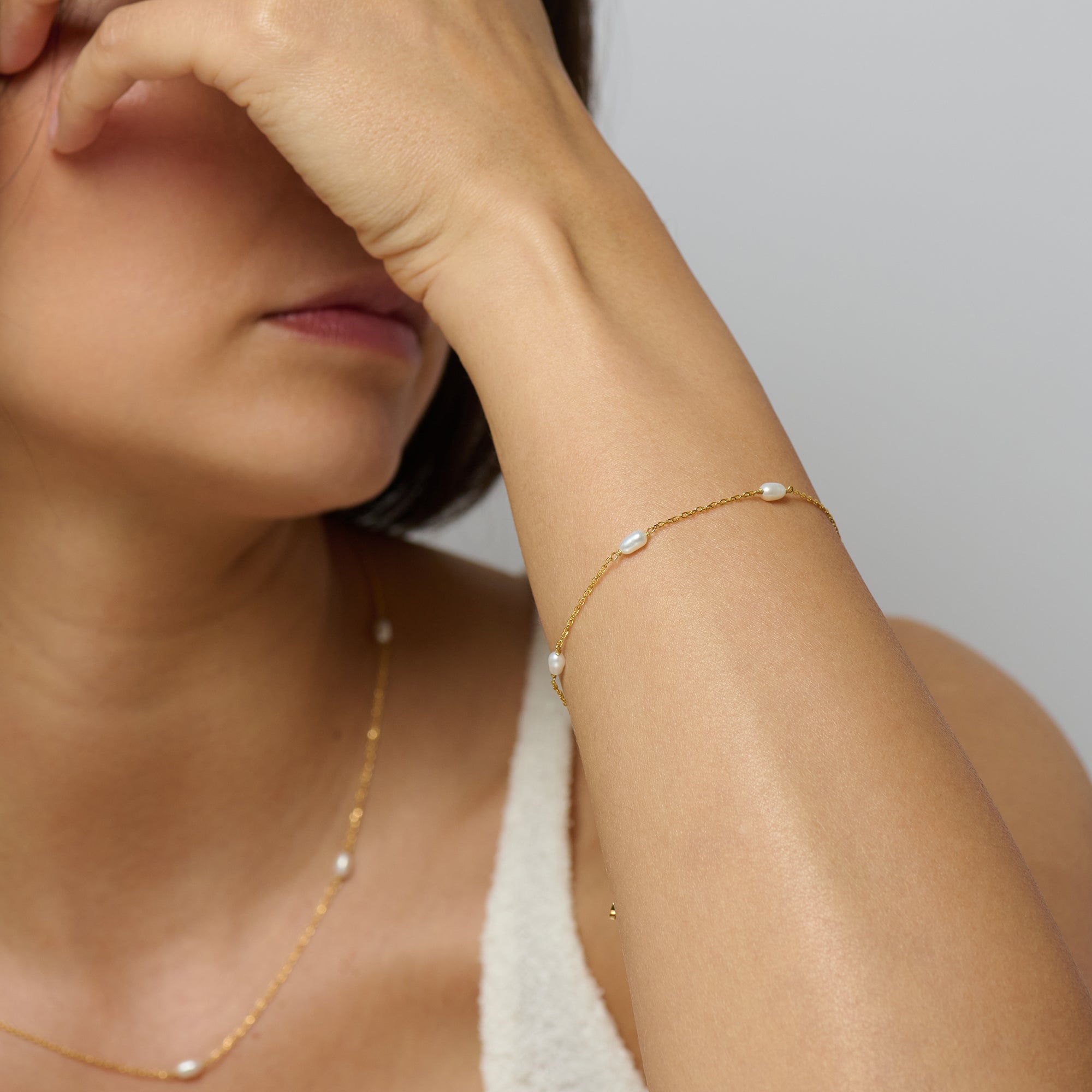 An 18k gold vermeil chain bracelet adorned with mini baroque freshwater pearls. Part of a matching set with gold pearl necklace.