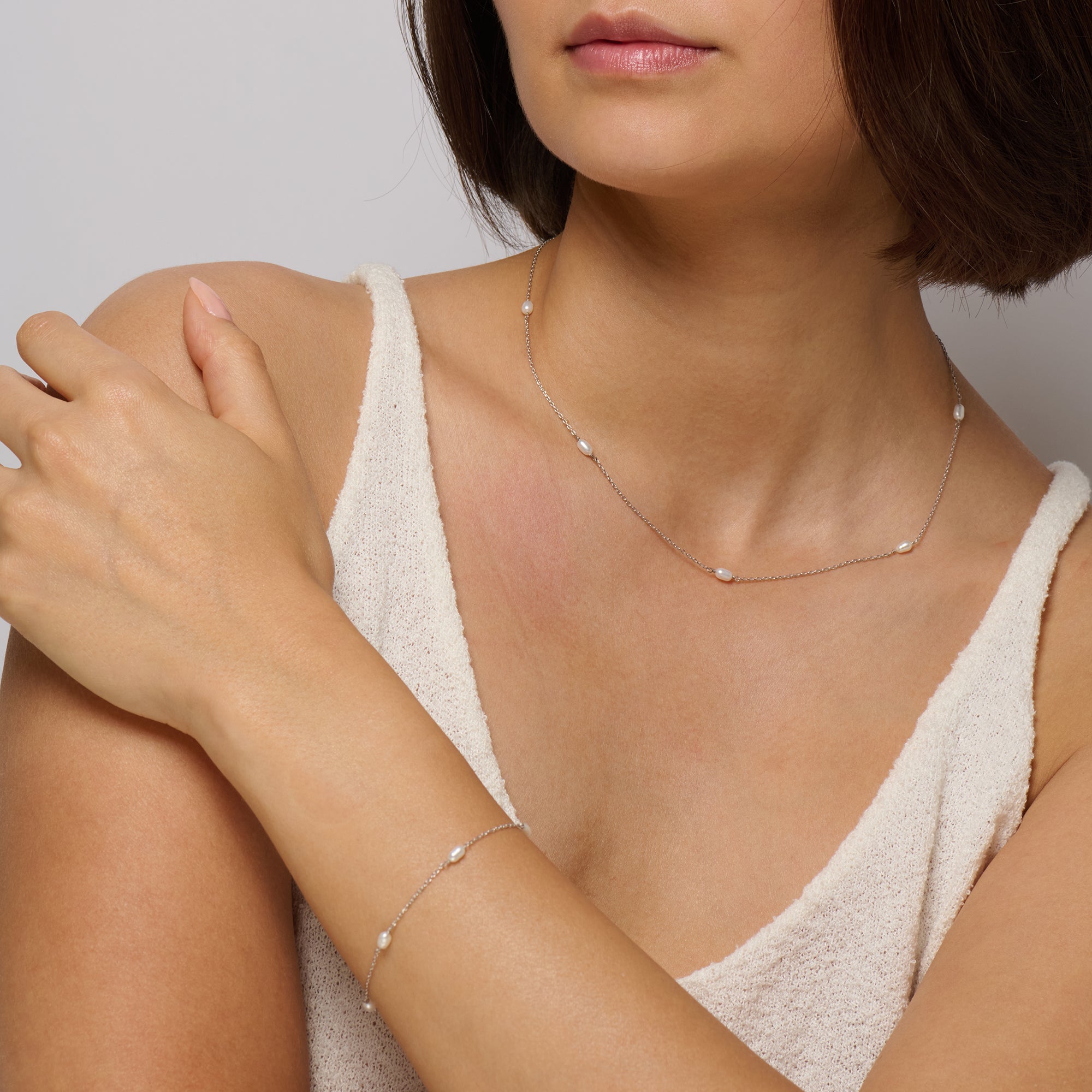 Sleek silver and iridescent pearls pair on chain necklace with matching bracelet