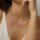 A silver pearl necklace with a matching silver pearl bracelet