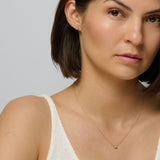 A matching set of gold diamond stud earring and gold diamond pendant chain necklace
